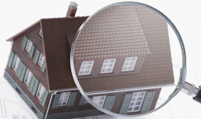 A magnifying glass is over the top of a house.
